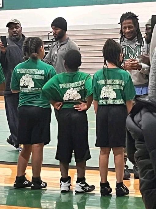 CWA girls in team gear on the mat