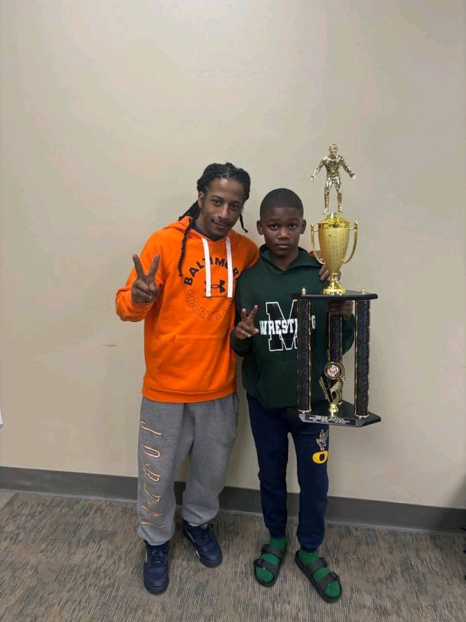 Coach Coles with a young wrestler and his trophy